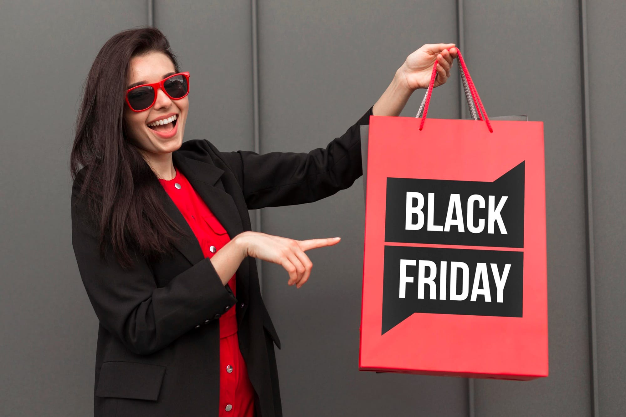 Mulher segurando uma bolsa vermelha e preta com o escrito branco Black Friday