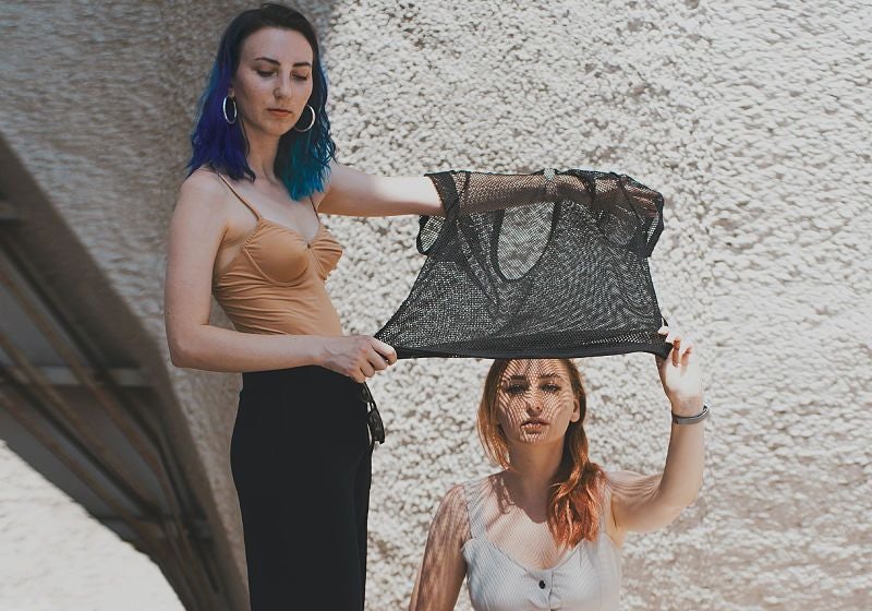 Duas mulheres segurando uma peça de roupa customizada