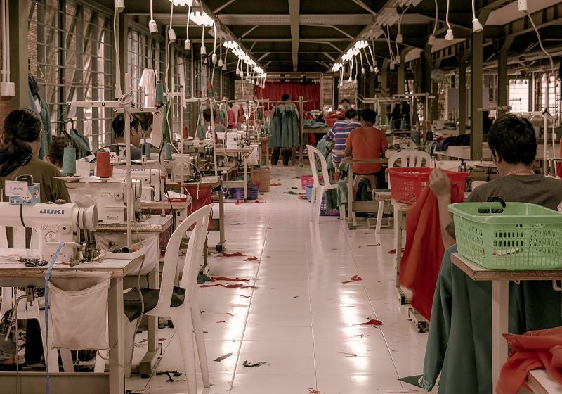 Linha de produção de roupas, com diversas máquinas de costura