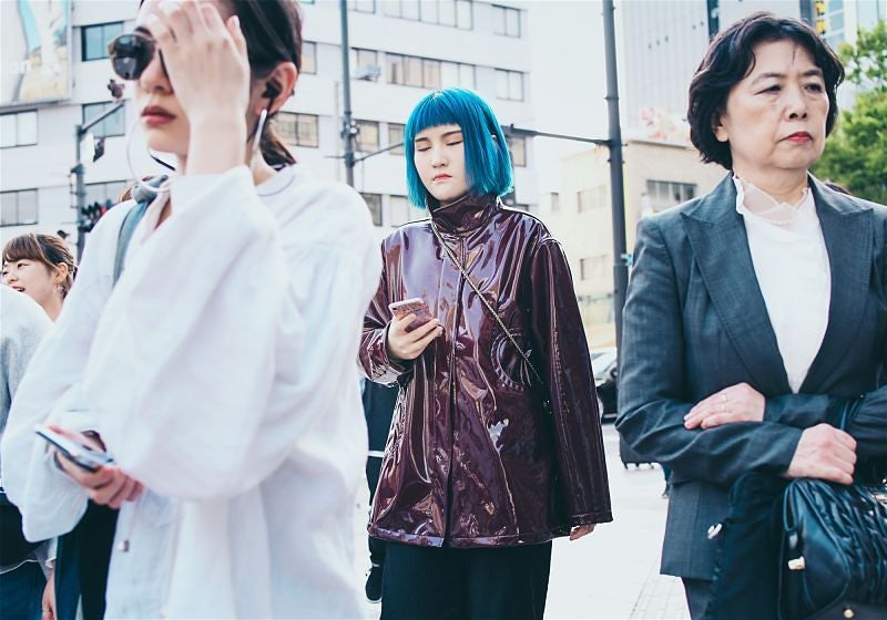 Pessoas japonesas em rua e ao centro garota de jaqueta com cabelo azul